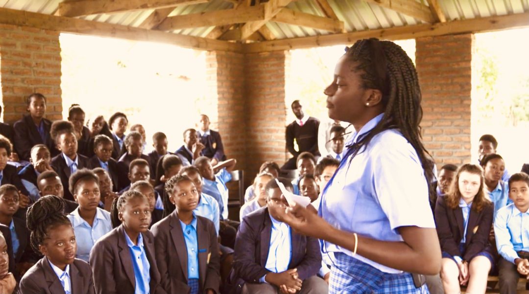 Lady explaining technology to some students.