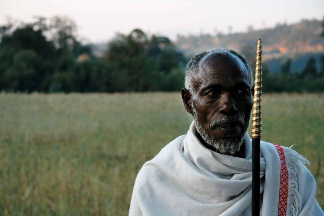 A man holding a staff staring into the distance